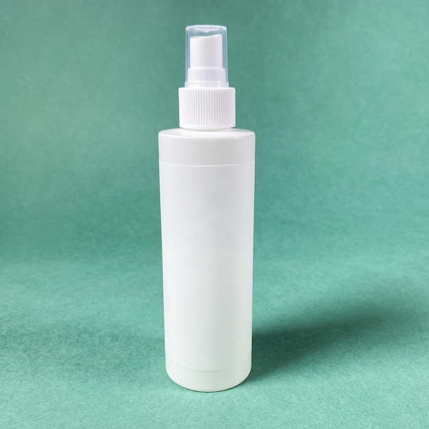 White blank spray plastic bottle on green paper