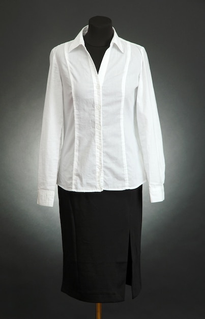 White blouse and black skirt on mannequin on black background