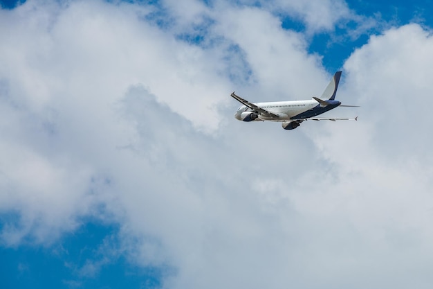 White blue passenger airplane flying in the sky amazing clouds in the background travel by air