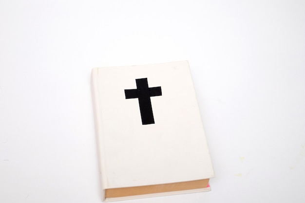 White book with a cross on the cover. Holy Bible book on white background.