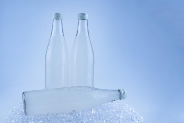 A white bottle with a soda drink on ice isolated