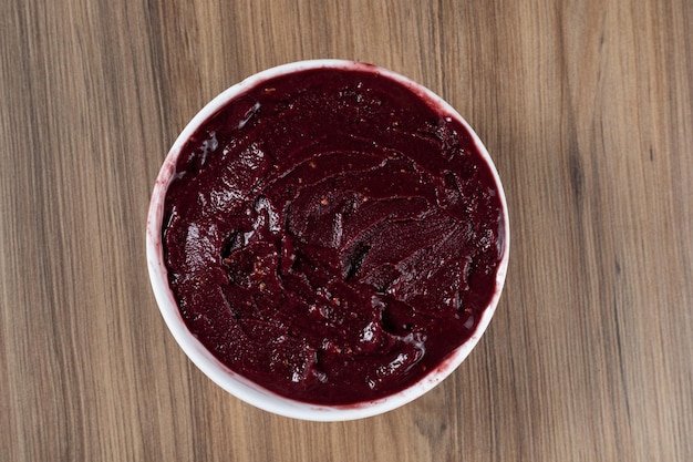 White Bowl of Brazilian Frozen Acai Berry on a wooden desk Top view