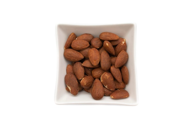 A white bowl with almonds isolated on white background The almond is the fruit of the almond tree