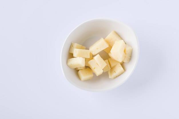 White bowl with pieces of tasty pecorino cheese on white background