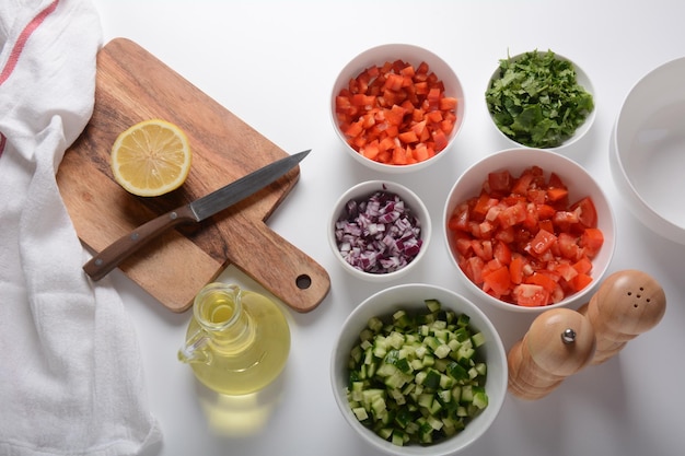 White bowls with grated vegetables of different colors Cooking board with Ingredients ready for the salad