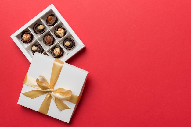 White box with chocolates candies and golden tape top view with copy space