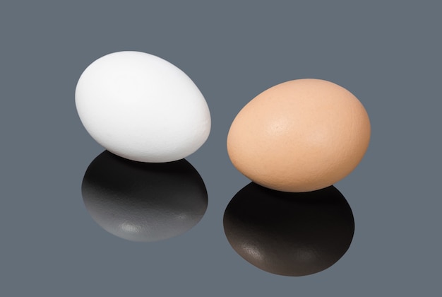 White and brown chicken eggs on gray background