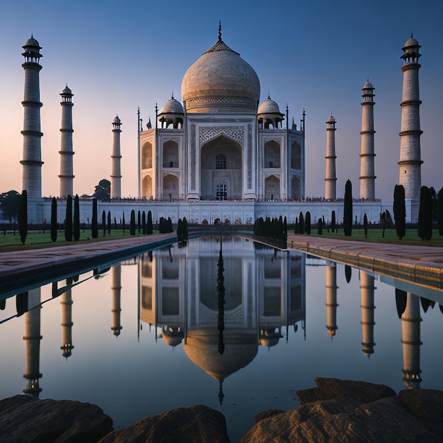 a white building with columns and a reflection of the building in the water.