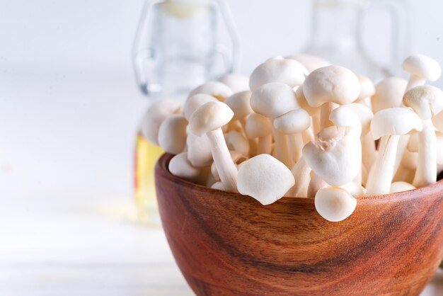 White buna-shimeji in wooden rustic bowl on white background