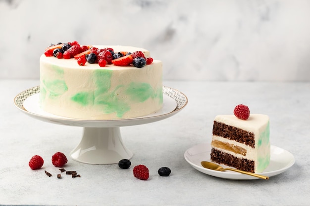 White cake berry sponge cake with fresh berries and sour cream on a white background