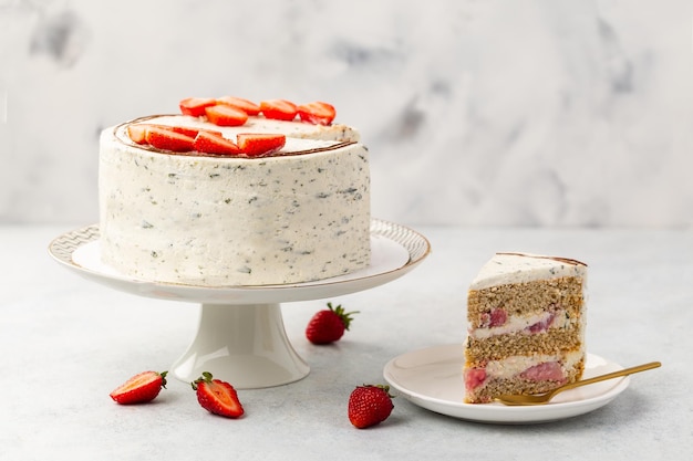 White cake strawberry sponge cake with fresh berries and basil and sour cream on a white background