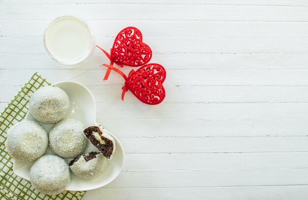 White cake with coconut flakes and a glass of milk top view