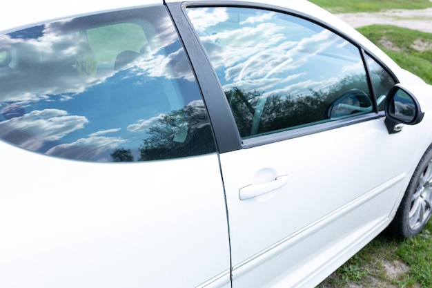 A white car with the door open and the window open.