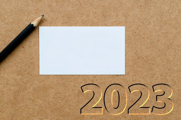 White card and pencil on neutral background with 2023 new year