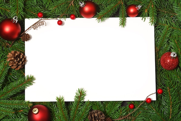 White card with red baubles and fir branches background