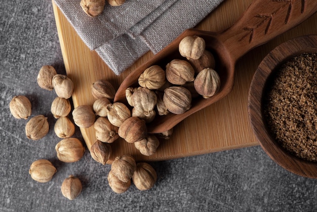 White cardamom in a wooden spoon and bowl Dry cardamom spice Cardamom seeds macro shot