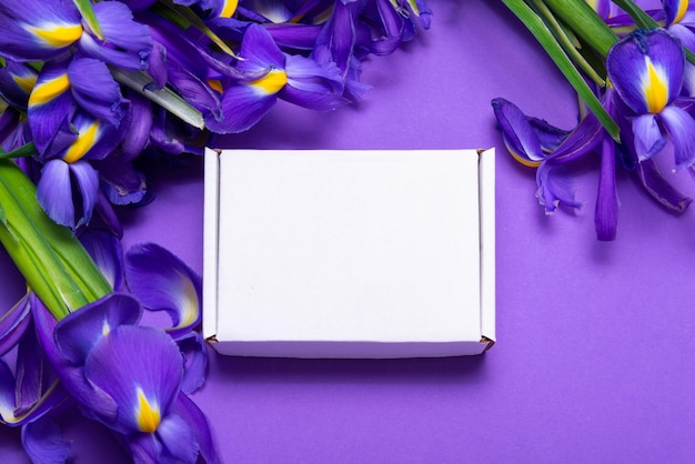 White carton cardboard box embellished with fresh iris flowers