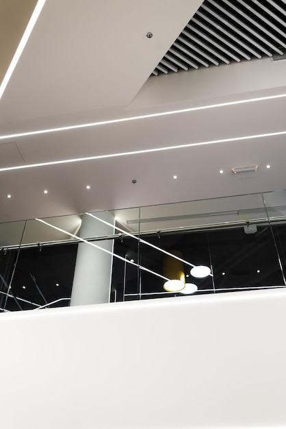 A white ceiling with lights and a glass railing.