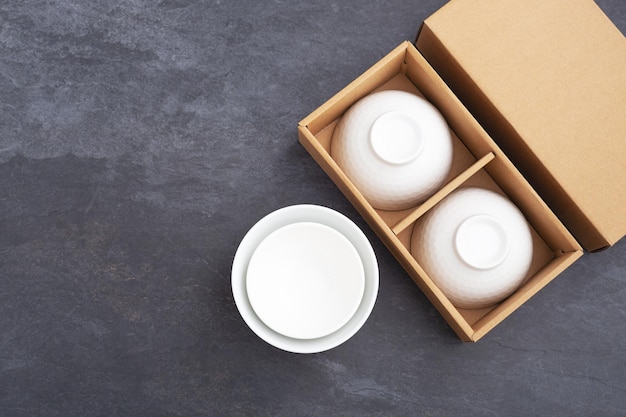 White ceramic bowl in package box on black stone background