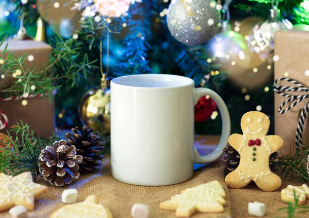 Photo white ceramic coffee cup and christmas decoration on woon table background. mockup for creative advertising text message or promotional content.