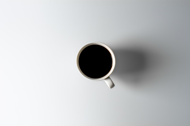 White ceramic coffee cup on white desk.