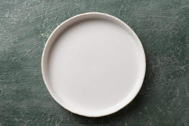 White ceramic empty plate on green background