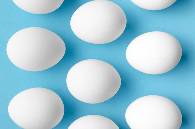 White chicken eggs on blue backgroundClose up