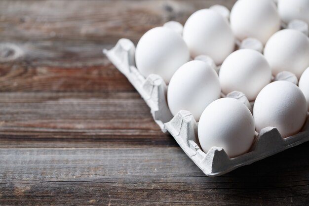 White chicken eggs on old wooden table