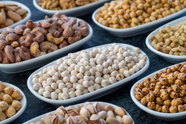 White Chickpeas in selective focus Nuts on plate on a dark background Walnut Chickpeas White Chickpeas Dry mulberry almond cashew pistachio Types of nuts on the plate