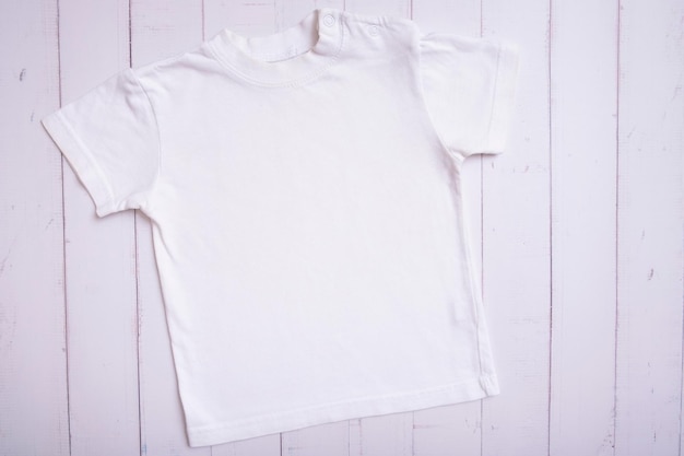 White children39s tshirt mockup for logo text or design on wooden background top view