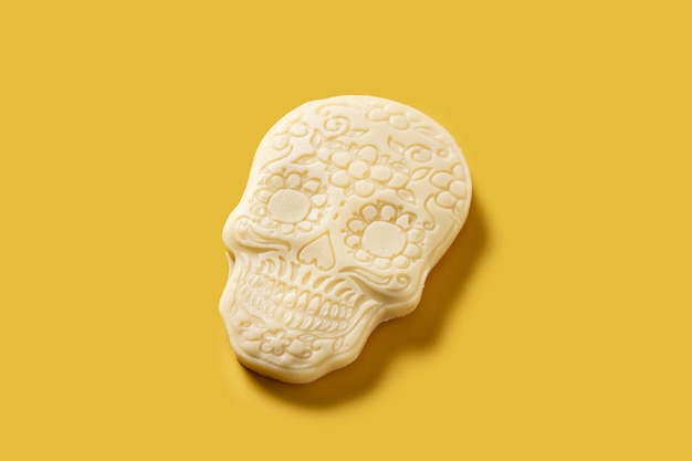 White chocolate Mexican skull on yellow background