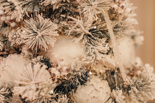 White Christmas background snow covered Christmas tree branches decorated with snowflakes