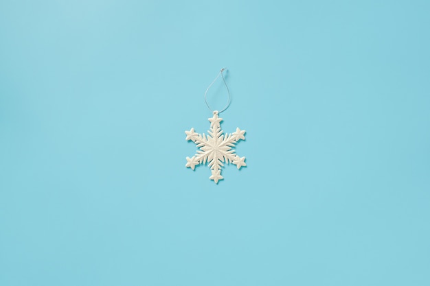 White christmas decoration snowflake toy on blue background. Merry christmas or Happy new year. 