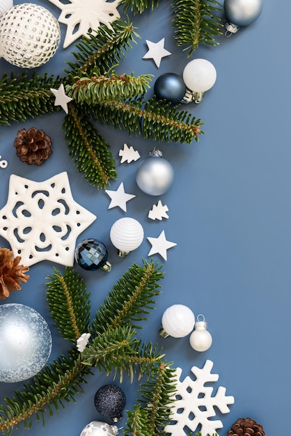 White Christmas decorations and fir branches on a blue top view with copy space