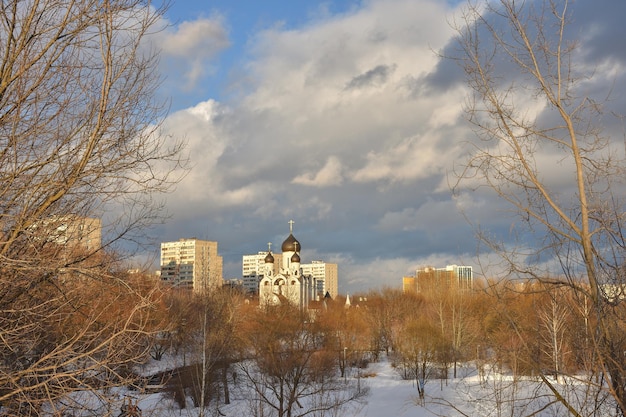 White church with black domes on the background of residential buildings