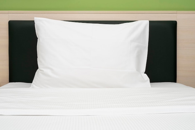 White clean pillow on a bed at a hotel room front view