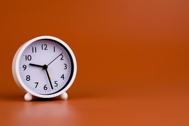 White clock on brown background time concept working with time Planning time for life