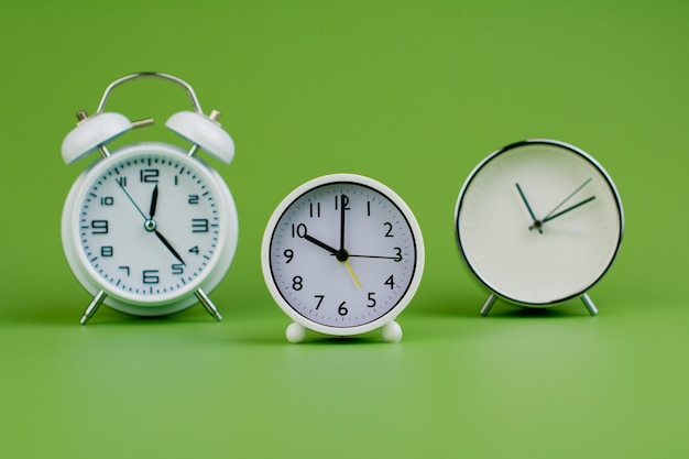 White clock on green background concept of time time is important to work