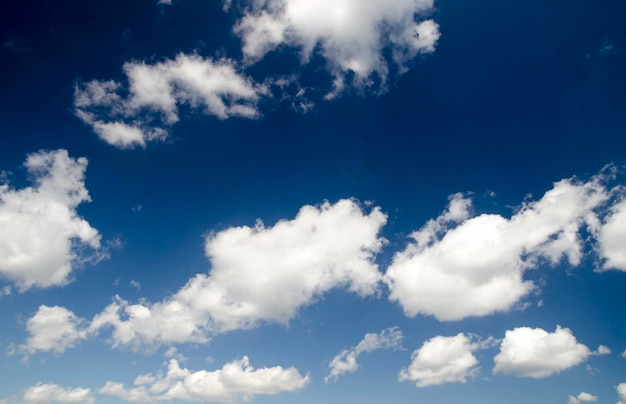 White clouds isolated over deep blue summer sky background natural wallpaper background