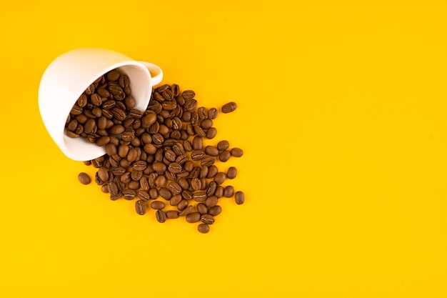 White coffee cup with beans Yellow background Copy space