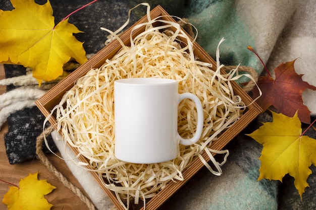 White coffee mug mockup with rustic wooden gift box and fall maple leaves.  Empty mug mock up for design promotion, styled template