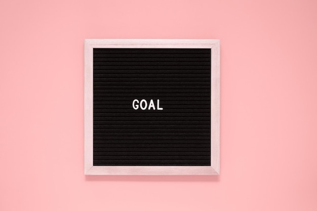 White color letter in word goal on black felt board backgroundMotivation inspiration