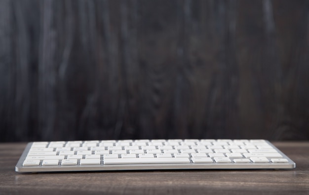 White computer keyboard on wooden table.