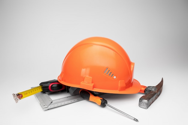 White construction helmet, tape measure, hammer, screwdriver. Concept architecture, construction, engineering, design, repair. Copy space.