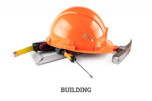 White construction helmet, tape measure, hammer, screwdriver. Inscription construction. Concept architecture, construction, engineering, design, repair.