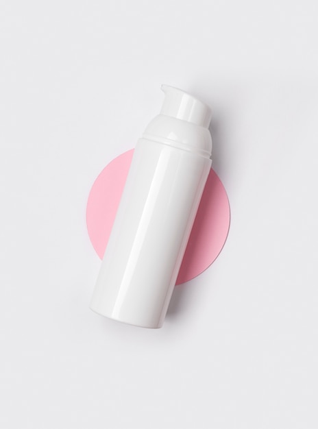 White cosmetic bottle an on creative minimal table.