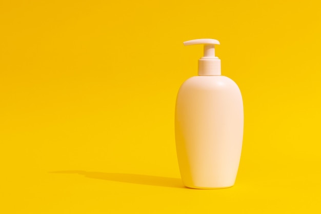 white cosmetic bottle on a yellow