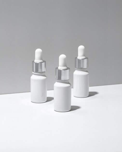 White cosmetic bottles on white