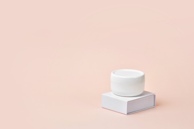 White cosmetic cream jar on stand