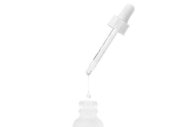 White cosmetic glass jar Pipette with dripping outflowing liquid into a jar Isolated on white background Hyaluronic acid Serum for the face Hydration